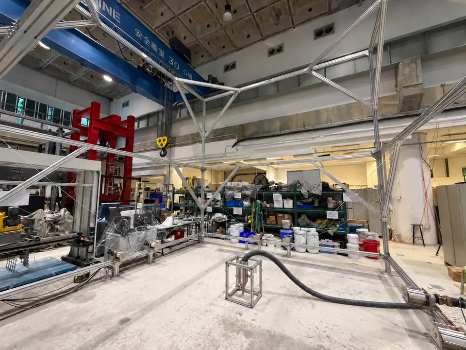 AI-edited concept showing a compact concrete-printing nozzle within the central metal carrier, connected to a flexible feeding hose